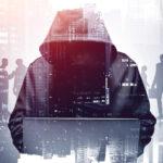 Unrecognizable,Young,Hacker,In,Hoodie,Using,Laptop,In,Blurry,City.